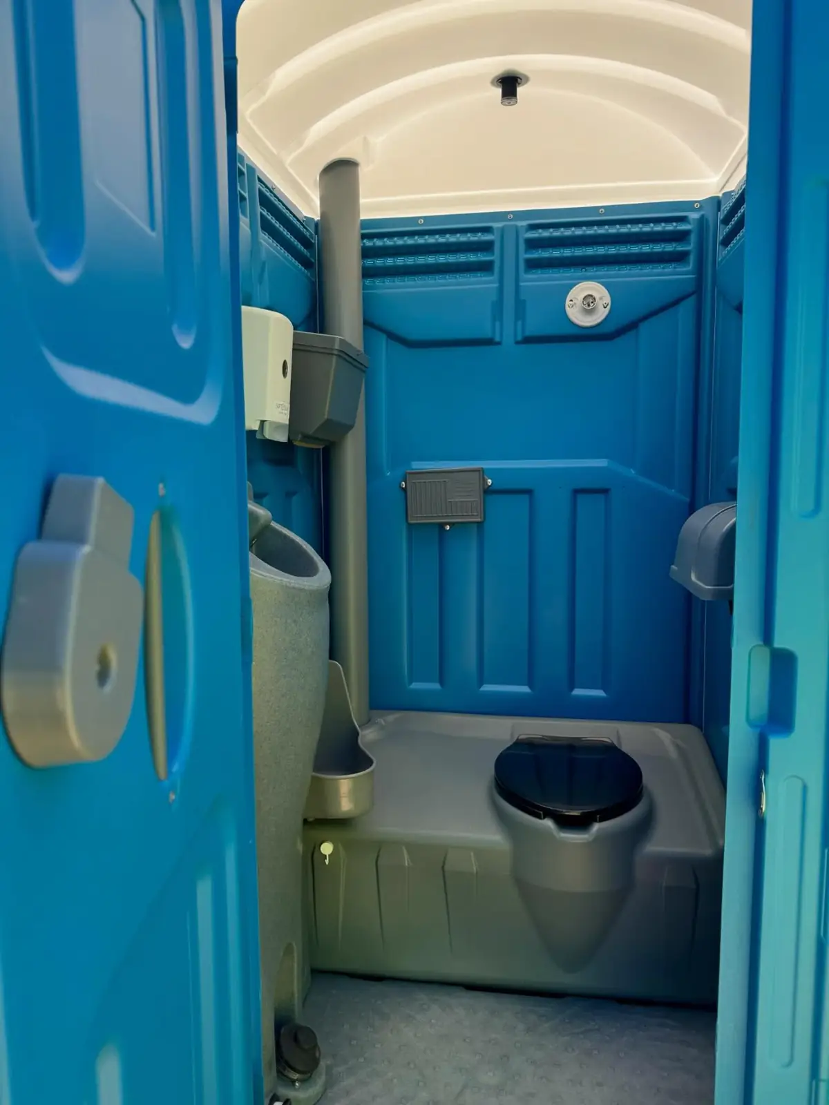 Interior of a portable restroom with dispensers mounted on the wall
