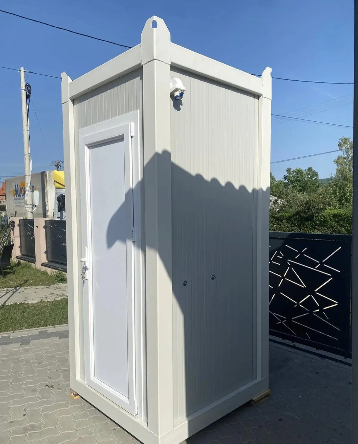 White single-stall luxury restroom cabin on a paved driveway